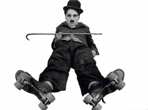Charlie Chaplin velünk szemben fekszik a földön, kissé széttárt lábain görkorcsolya, sétapálcáját a mellén tartja keresztben